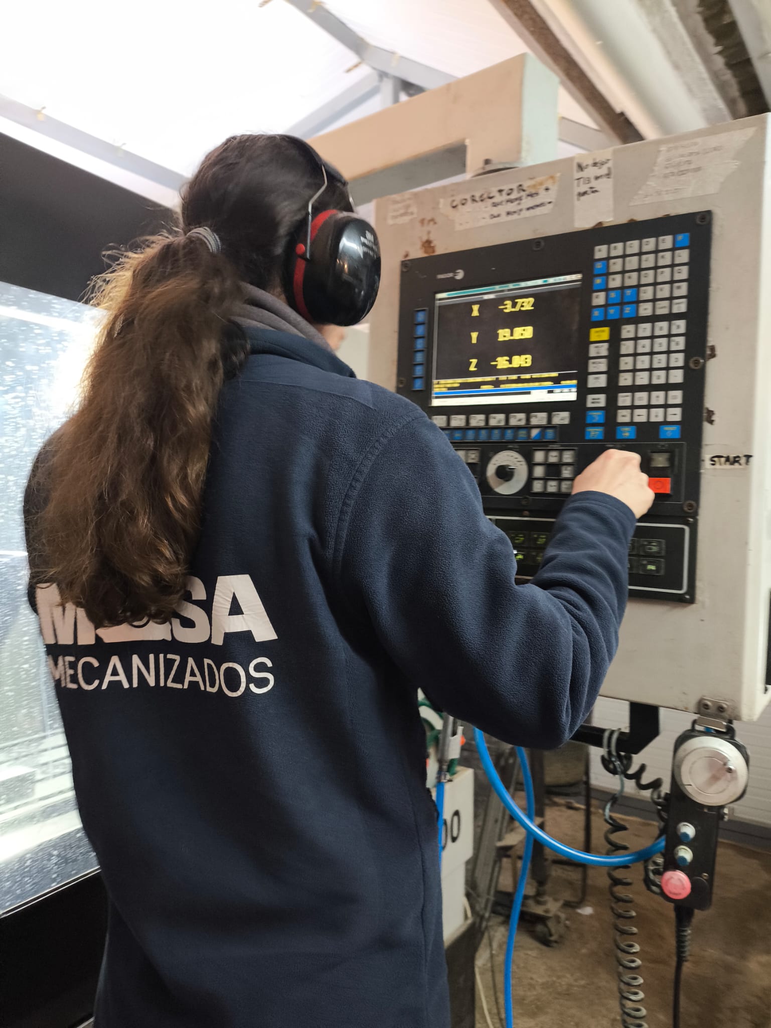 Operario MASA trabajando en el panel de control CNC